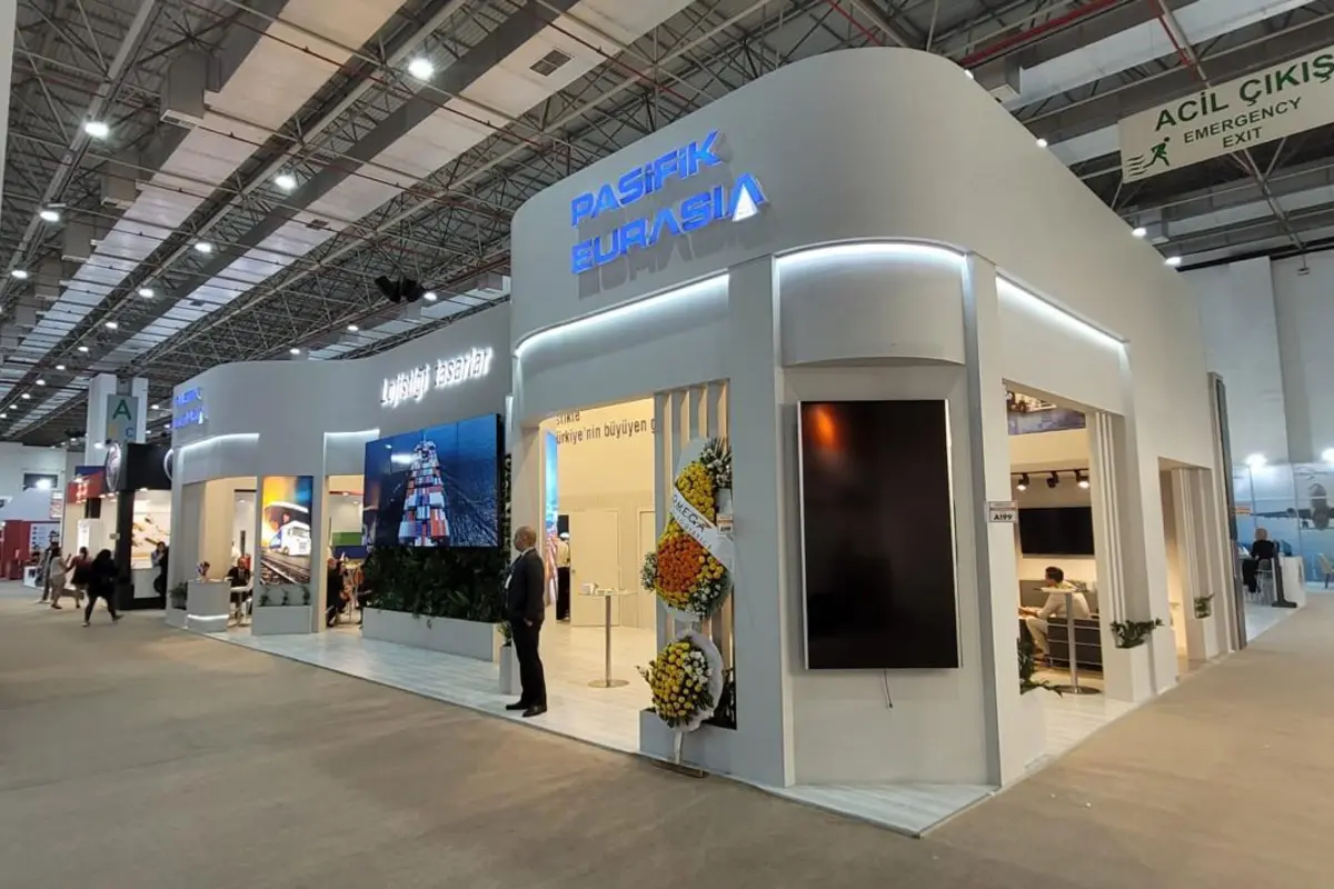 Pasifik Eurasia: Corporate stand with an illuminated facade and meeting areas.